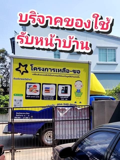 The yellow Leua-Kho donation truck parked at a house in Bangkok for a home pickup, with the project star logo and the list of items it collects on its side